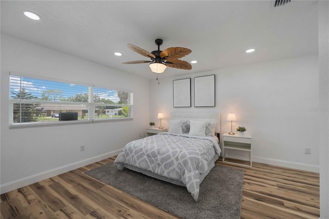 bedroom with dark hardwood / wood-style flooring and ceiling fan