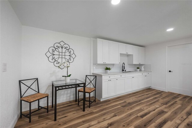 kitchen featuring decorative backsplash, dark hardwood / wood-style floors, white cabinetry, and sink