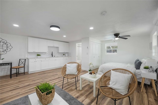 interior space featuring light hardwood / wood-style floors, sink, and ceiling fan