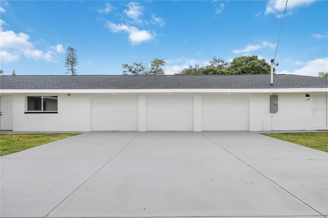 353 Suwanee Ave, Sarasota, FL 34243 - view of property exterior featuring stucco siding, roof with shingles, an attached garage, driveway, and a lawn