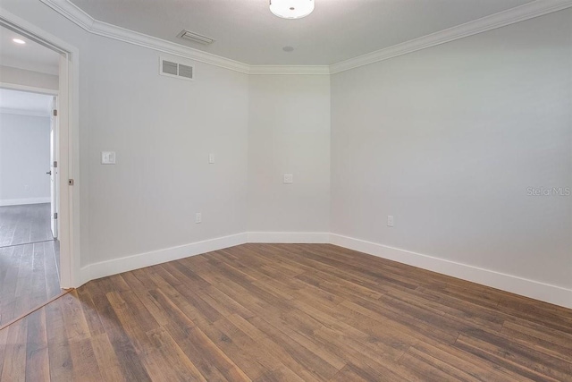 spare room featuring ornamental molding and dark hardwood / wood-style floors