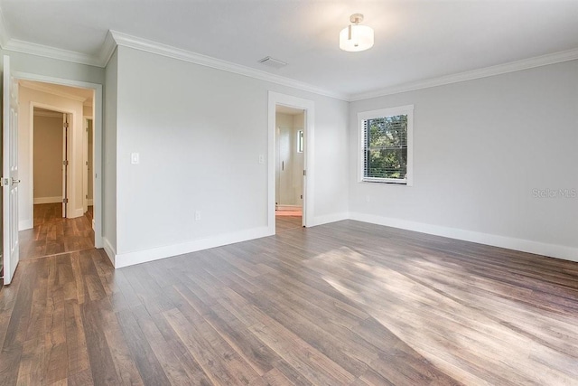 unfurnished room featuring ornamental molding and dark hardwood / wood-style floors