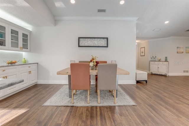 dining space featuring hardwood / wood-style flooring and ornamental molding