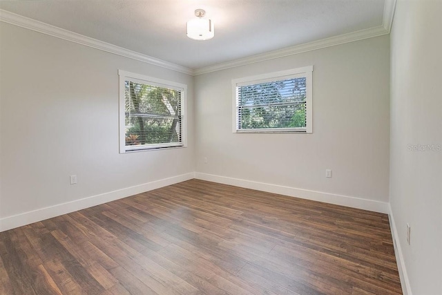 empty room with dark hardwood / wood-style flooring and ornamental molding