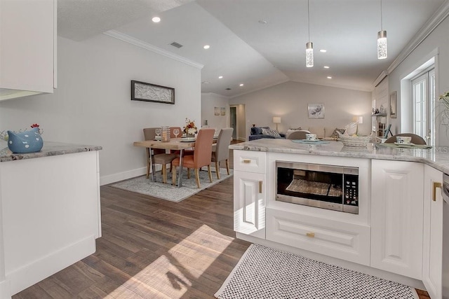 kitchen with white cabinetry, crown molding, and hanging light fixtures