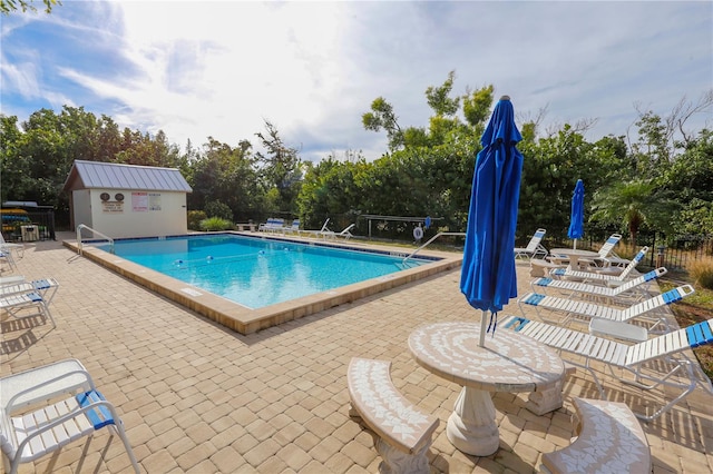 view of swimming pool featuring a patio area and an outbuilding