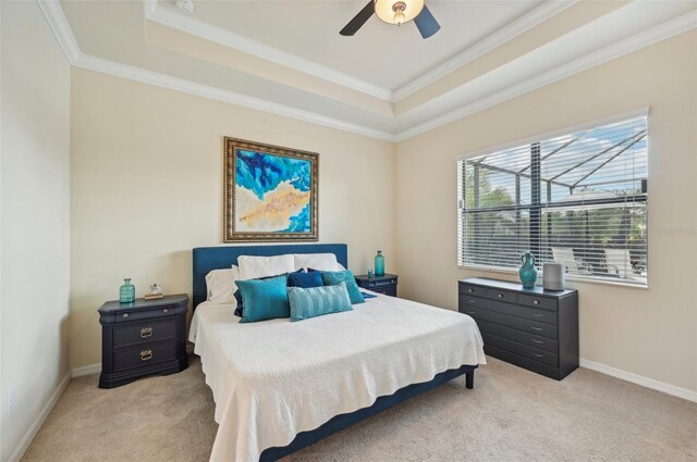 carpeted bedroom featuring crown molding, ceiling fan, and a raised ceiling