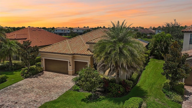 13215 Ramblewood Trl, Bradenton, FL 34211 - mediterranean / spanish-style home with stucco siding, decorative driveway, a tile roof, a garage, and a residential view