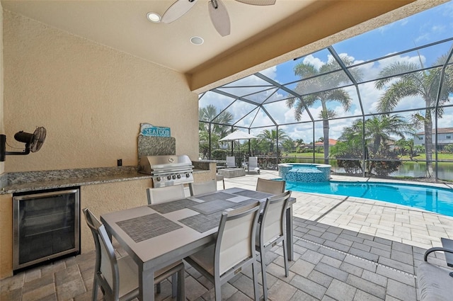 view of patio / terrace featuring ceiling fan, a grill, glass enclosure, an outdoor kitchen, and a pool with hot tub