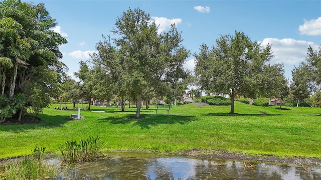 view of home's community with a water view and a lawn