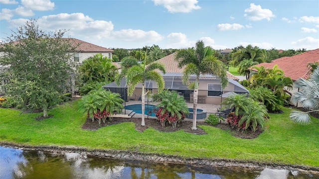 rear view of property with a yard, a water view, and a lanai