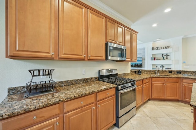 13215 Ramblewood Trl, Bradenton, FL 34211 - kitchen with stainless steel appliances, brown cabinetry, a sink, and dark stone counters