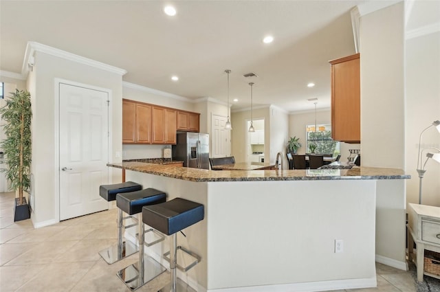 13215 Ramblewood Trl, Bradenton, FL 34211 - kitchen with dark stone counters, visible vents, recessed lighting, stainless steel refrigerator with ice dispenser, and a breakfast bar area