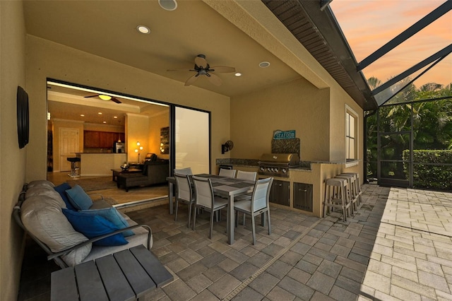 13215 Ramblewood Trl, Bradenton, FL 34211 - view of patio / terrace featuring outdoor dining space, an outdoor kitchen, grilling area, ceiling fan, and glass enclosure
