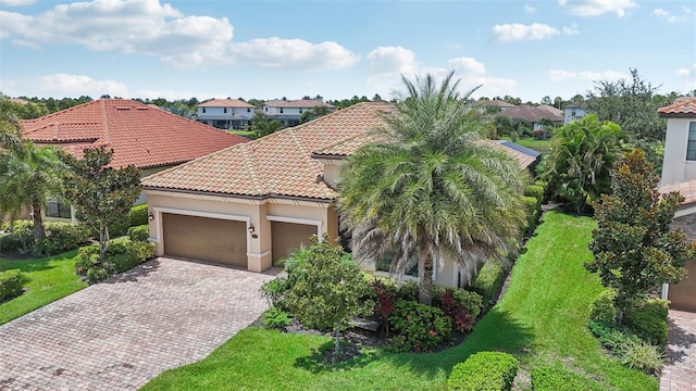 13215 Ramblewood Trl, Bradenton, FL 34211 - mediterranean / spanish-style home with a residential view, stucco siding, decorative driveway, a tile roof, and a garage