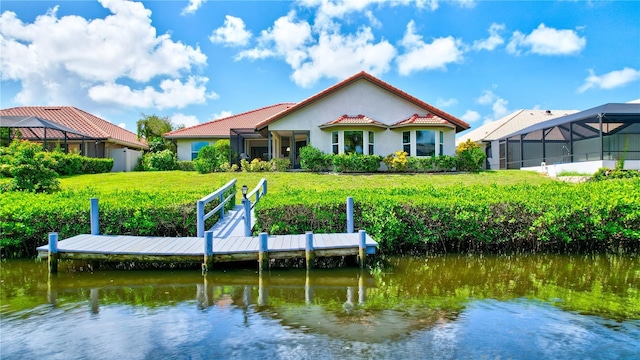 view of dock featuring a water view, glass enclosure, and a lawn