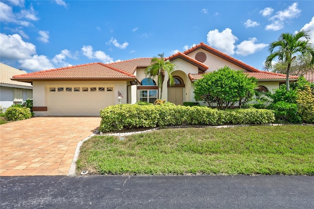 mediterranean / spanish home with a garage and a front yard