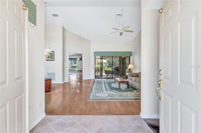 tiled entrance foyer with a towering ceiling and ceiling fan