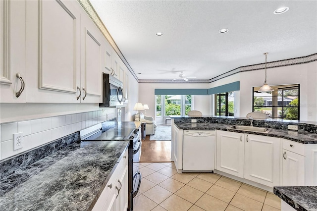 kitchen featuring white dishwasher, hanging light fixtures, range with electric cooktop, and white cabinets