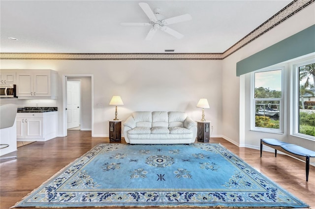 living room with dark hardwood / wood-style flooring and ceiling fan