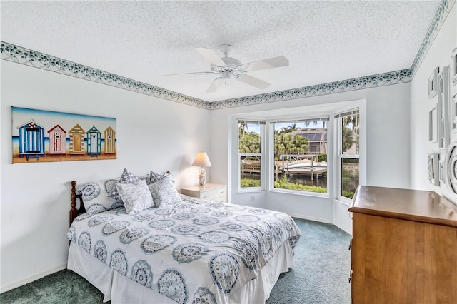 carpeted bedroom featuring ceiling fan and a textured ceiling