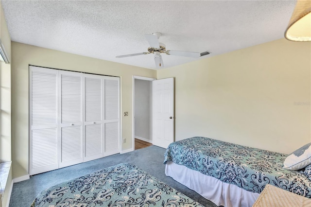 carpeted bedroom with a textured ceiling, ceiling fan, and a closet