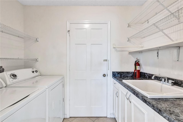 washroom with cabinets, sink, light tile patterned floors, and washer and clothes dryer