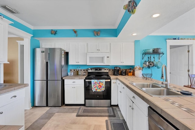 kitchen featuring appliances with stainless steel finishes, white cabinets, sink, and crown molding