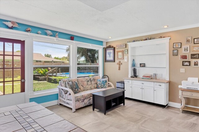 tiled living room with a textured ceiling and ornamental molding