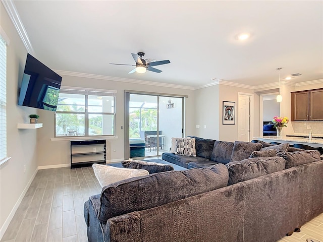 living room featuring light hardwood / wood-style flooring, plenty of natural light, ornamental molding, and ceiling fan