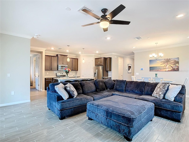 living room featuring crown molding and ceiling fan with notable chandelier