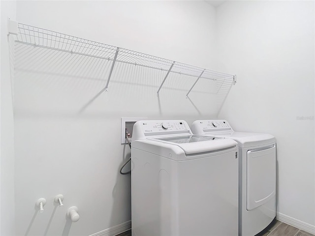 laundry area with hardwood / wood-style flooring and washer and clothes dryer