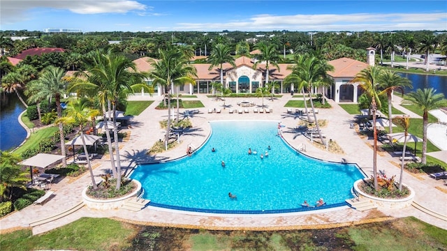 view of swimming pool featuring a water view and a patio area