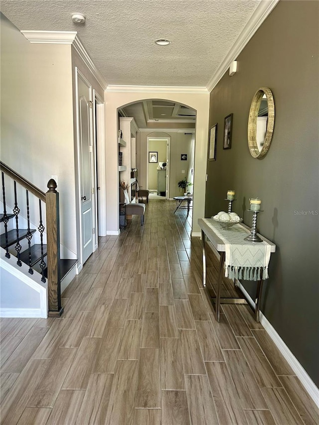 hall featuring crown molding, a textured ceiling, and hardwood / wood-style flooring