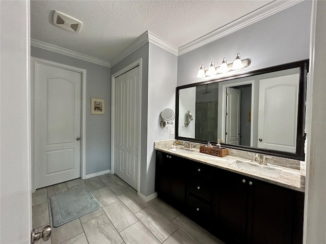 bathroom with double sink vanity, crown molding, tile patterned floors, and a textured ceiling