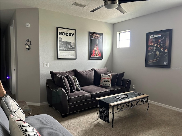 living room featuring carpet flooring, ceiling fan, and a textured ceiling