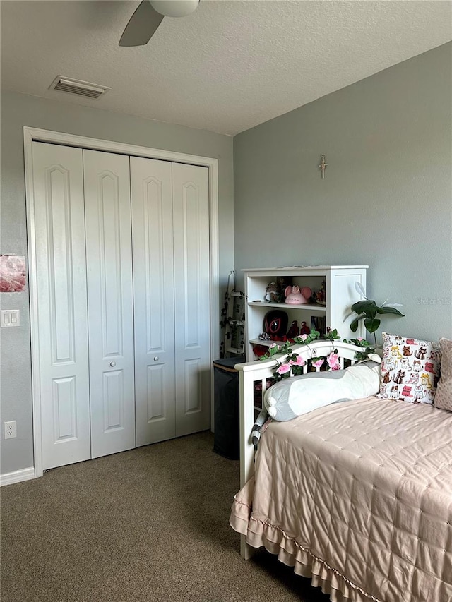 carpeted bedroom featuring a textured ceiling, ceiling fan, and a closet