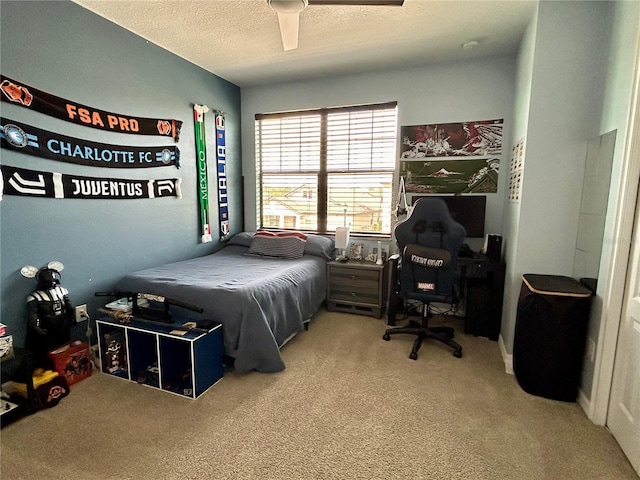 bedroom featuring a textured ceiling, ceiling fan, and carpet floors