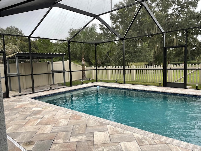 view of pool with a patio and glass enclosure