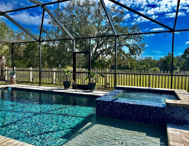 view of pool with glass enclosure and an in ground hot tub