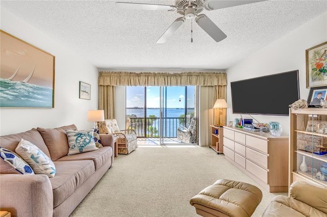 carpeted living room with a textured ceiling and ceiling fan