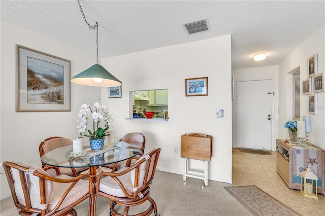 tiled dining area featuring a textured ceiling