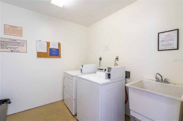 clothes washing area with washer and clothes dryer and sink