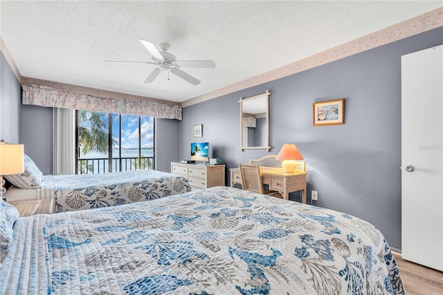 1602 Stickney Point Rd Unit 305, Sarasota, FL 34231 - bedroom featuring wood finished floors, a ceiling fan, a textured ceiling, and access to exterior
