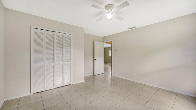 unfurnished bedroom with ceiling fan, a closet, and light tile patterned flooring