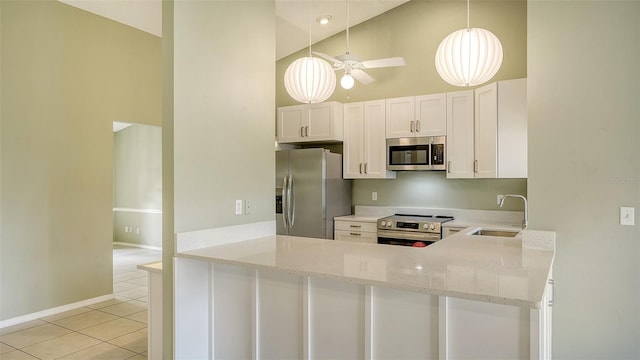 kitchen with light tile patterned floors, appliances with stainless steel finishes, sink, and kitchen peninsula