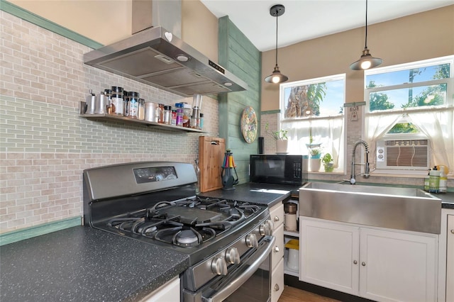 kitchen with sink, white cabinetry, hanging light fixtures, extractor fan, and stainless steel range with gas cooktop