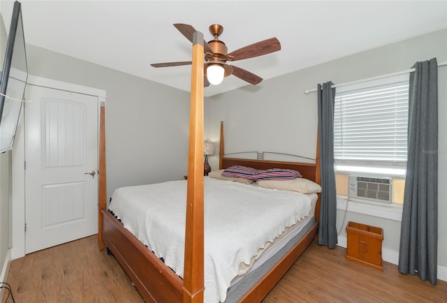 bedroom featuring ceiling fan, cooling unit, and light wood-type flooring