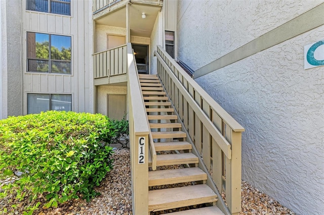 property entrance with board and batten siding and stucco siding