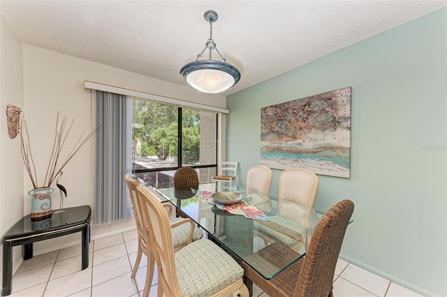 dining space with a textured ceiling and light tile patterned flooring